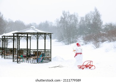 Snowman With Red Sled In The Park