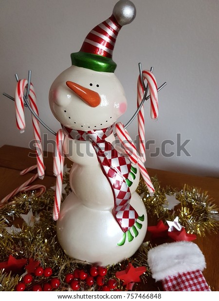 Snowman Sitting On Table Holding Candy Stock Photo Edit Now