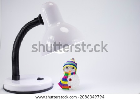 Snowman under the light of a lamp