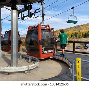 Snowmass Village, CO / USA - September 28, 2020: Aspen Snowmass Ski Resort's Lift Operator Helping Tourists Get In The Lift Ride On Fall