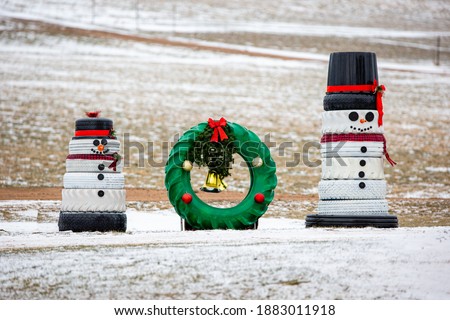 Snowmen and a wreath made out of recycled tires for Christmas decorations, horizontal