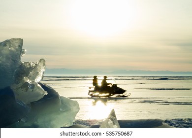 A Snowmobile On The Baikal Lake Ice  At Sunset