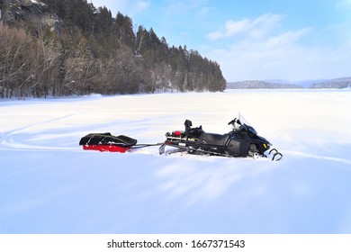 Snowmobile Pulling A Trailer Parked In The Snow