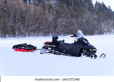 Snowmobile With A Trailer Parked On A Frozen Lake