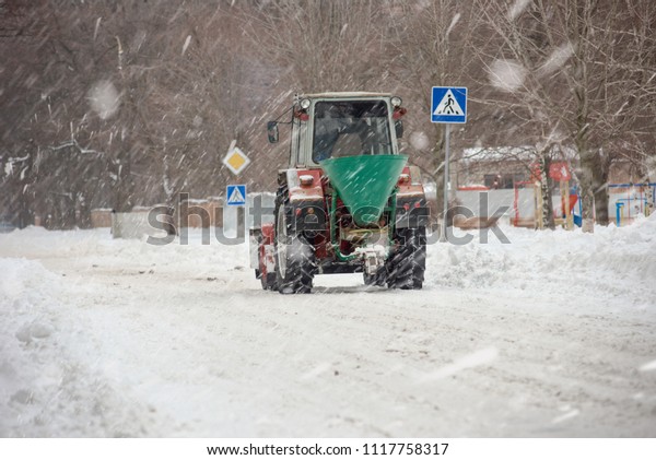 Snowplow\
cleaning road in city after heavy\
snowfall