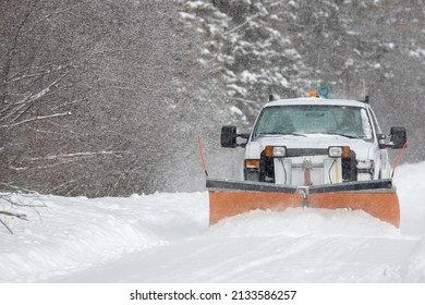 A snowplow clearing a rural road in Ontario during a winter storm
