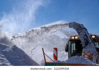 a snowplow is clearing snow from the road