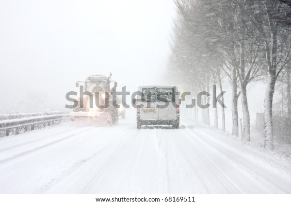 Snowplow driving\
in snowstorm in the\
Netherlands