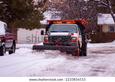 Snowplow plowing a residential street