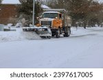 Snowplow truck removes snow from residential area during heavy snowfall