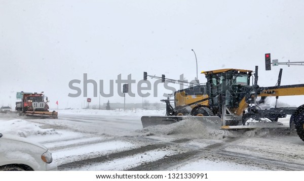 Snowplows clear snow from streets during a\
snow storm in\
Minnesota.
