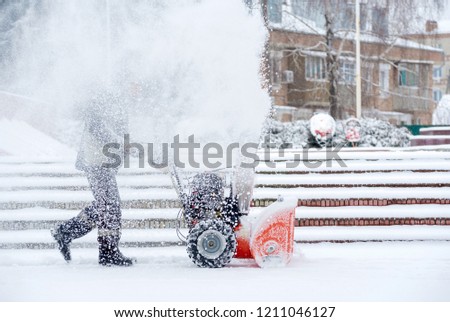 Snow-removal work with a snow blower. Man Removing Snow. heavy precipitation and snow piles