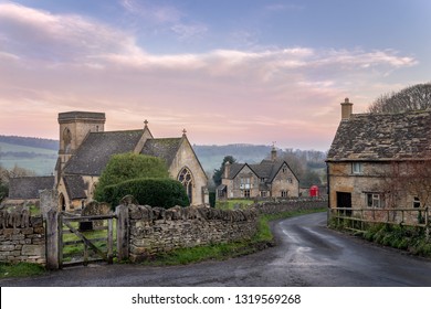 Snowshill church in the Cotswolds gloucestershire with lane leading past a cottage towards red telephone box and country pub