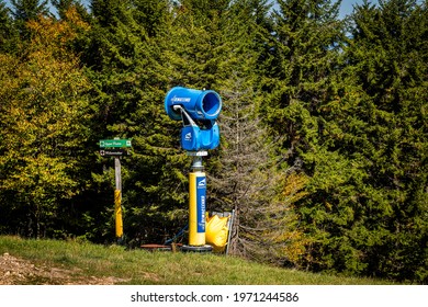 Snowshoe, USA - October 6, 2020: Demaclenko Snow Maker Snowmaking Fan Machine At Ski Resort Slope In Autumn With Skiing Sign For Black Diamond Widowmaker Route And Upper Flume Green In West Virginia