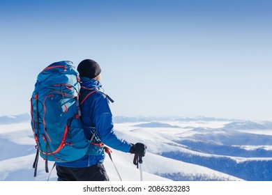Snowshoe walker running in powder snow with beautiful winter landscape. Traveler with backpack and winter mountain panorama. Outdoor winter activity and healthy lifestyle