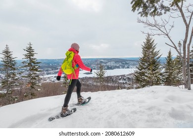 Snowshoeing People In Winter Forest With Snow Covered Trees On Snowy Day. Woman On Hike In Snow Hiking In Snowshoes Living Healthy Active Outdoor Lifestyle. Mont Tremblant, Laurentians, Quebec Canada.