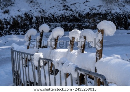 In a snowstorm, the bridge's railings are covered in snow, forming unusually shaped snowballs above the metal supports and guardrails, creating a picturesque landscape with a calm glow of light. Foto stock © 