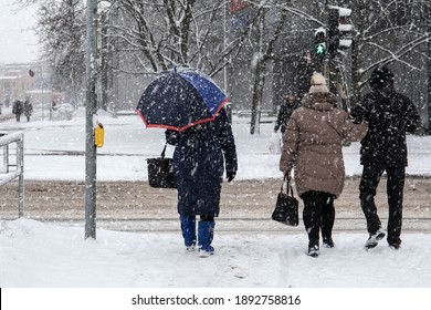 In Snowstorm People Cross The Street. Winter, Frost And Urban Environment