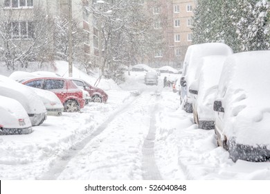 Snowstorm, snow-covered street and cars with a lonely pedestrian