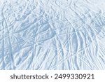 Snowy abstract off-piste skiing background with ski and snowboard trails and tracks on new virgin powder snow. morning sunrise or evening sunset time at alpine mountain resort