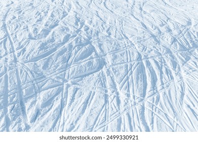 Snowy abstract off-piste skiing background with ski and snowboard trails and tracks on new virgin powder snow. morning sunrise or evening sunset time at alpine mountain resort - Powered by Shutterstock