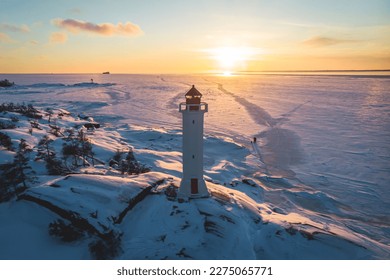 Snowy aerial drone view of Povorotny lighthouse, Vikhrevoi island, Gulf of Finland, Vyborg bay, Leningrad oblast, Russia, winter sunny day with blue sky, lighthouses of Russia travel