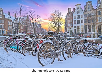 Snowy Amsterdam in the Netherlands in winter at sunset