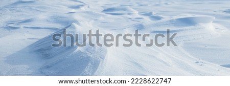 Snowy background, snow-covered surface of the earth after a blizzard in the morning in the sunlight with snow drifts