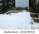 A snowy boat launch area at the edge of a wharf.