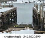 A snowy boat launch area at the edge of a wharf.