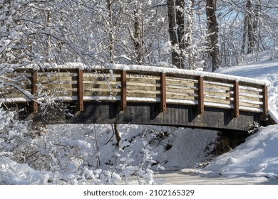 Snowy Bridge Over A Stream In The Park