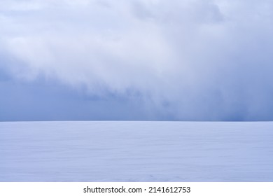 A snowy desert with an impending snow cloud on the horizon. Natural background. Copy space.                                - Shutterstock ID 2141612753