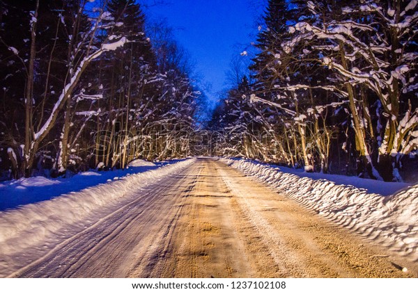 Snowy evening road. Winter tale on the road. Travel\
by car