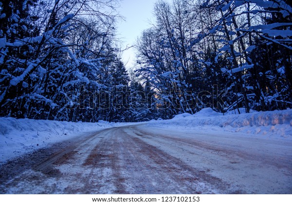 Snowy evening road. Winter tale on the road. Travel\
by car
