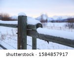 Snowy fence with the Tetons in the background in Wyoming