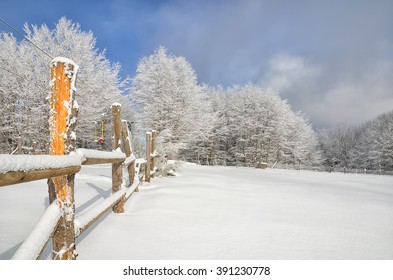 Snowy Field With Enclosure At Sunset In Winter