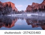 Snowy foggy winter morning reflection in Merced River of El Captain and Half Dome in Yosemite National Park California 