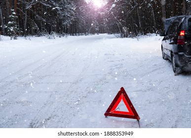 In A Snowy Forest, A Car Broke Down On The Road. A Red Warning Triangle Is Installed On The Snow