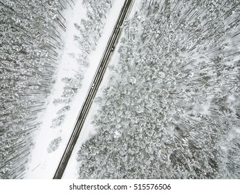 Snowy Forrest With A Road Captured From Above With A Drone.