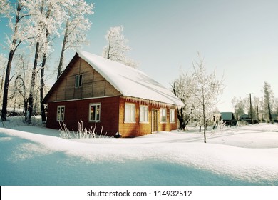 Snowy hills in Russian countryside in morning, red wooden house windows turned to east - Powered by Shutterstock