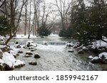 The snowy landscape at the cascade of the stream Eisbach in the famous English Garden in Munich, Germany