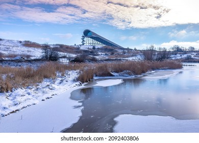 Snowy landscape with hills and meadows under a blue sky in Winter season. Buytenpark Zoetermeer, the Netherlands