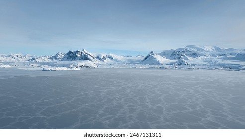 Snowy landscape with majestic mountains in background. Aerial fly over frozen polar ocean in Antarctica, covered snow wild desert land. Beautiful winter scene, wild nature wallpaper. Travel to Arctic - Powered by Shutterstock