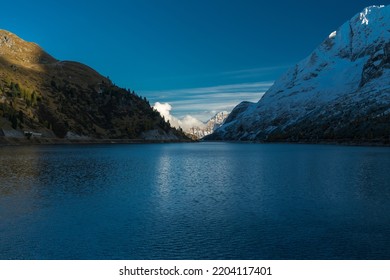 Snowy Marmolada Glacier and Lago Fedaia (Fedaia Lake), Fassa Valley, Trentino Alto Adige, an artificial lake and a dam near Canazei city, located at the foot of Marmolada massif, Dolomiti Range, Italy - Shutterstock ID 2204117401