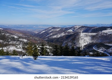 Snowy meadow at Silesian Beskid Mountains range on european Bialy Krzyz in Poland with clear blue sky in 2022 warm sunny winter day on February.