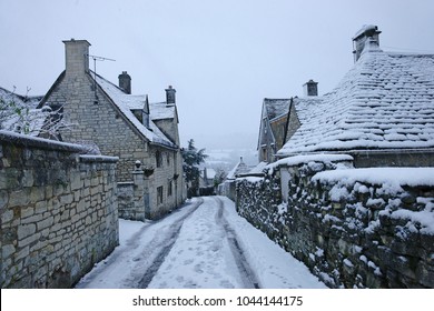 A Snowy, Misty Winter Scene With Falling Snow In The Village Of Painswick In The Heart Of The Cotswolds, Gloucestershire, England, UK