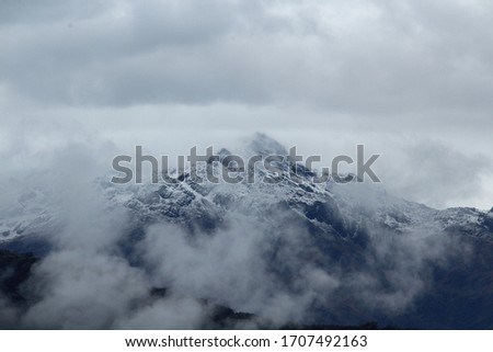 Snowy montain peak with some clouds