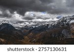 Snowy mountain range under dramatic cloudy sky in Peru