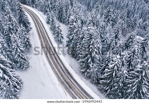 Snowy\
mountain road and forest, drone view. Snowy mountain road and\
forest, drone view. Wonderful winter\
landscape.