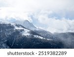 Snowy mountains in moving fog clearance. Snowy landscape Swiss Alps. 